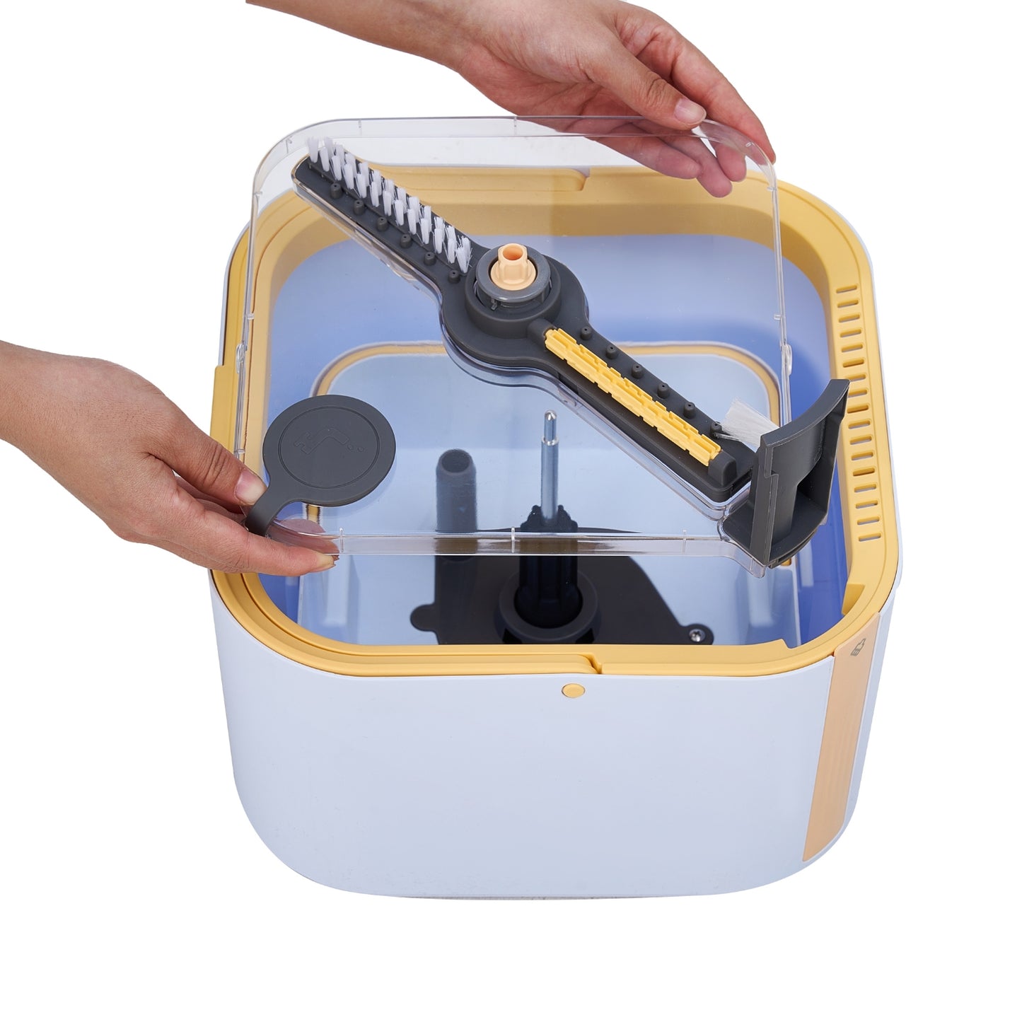 Spin11 clear cover being demonstrated by two hands, showing the brush head, bristles, and internal mechanism against a white background.