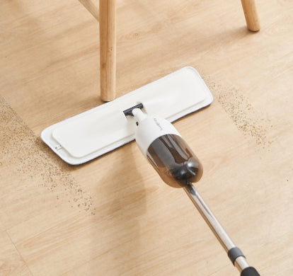 white spray mop cleaning a laminate wood floor