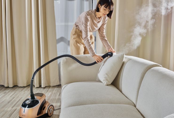 woman steam cleaning couch 