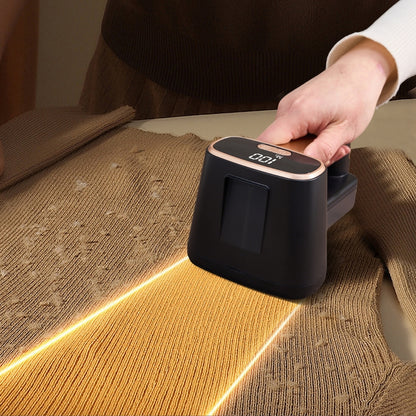 FS2 black and gold fabric shaver removing fuzz from a brown sweater