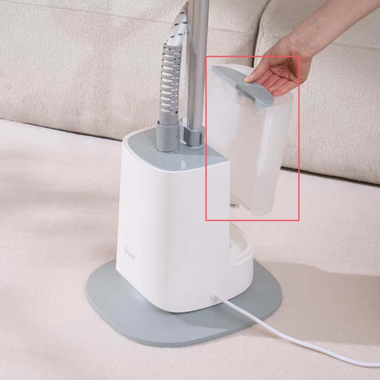 White handheld steamer with gray base on a beige surface