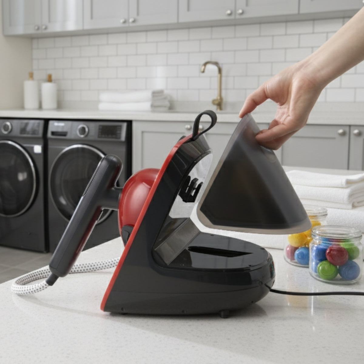SS1500+Red+Person using a handheld steamer on a kitchen counter with laundry machines in the background