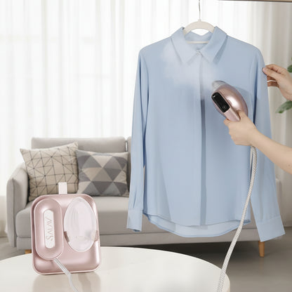 SS1500+RoseGold+Person using a handheld steamer on a light blue shirt in a living room setting.