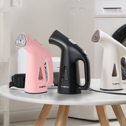 TS38 + Pink + Three handheld steamers in pink, black, and white on a white table.